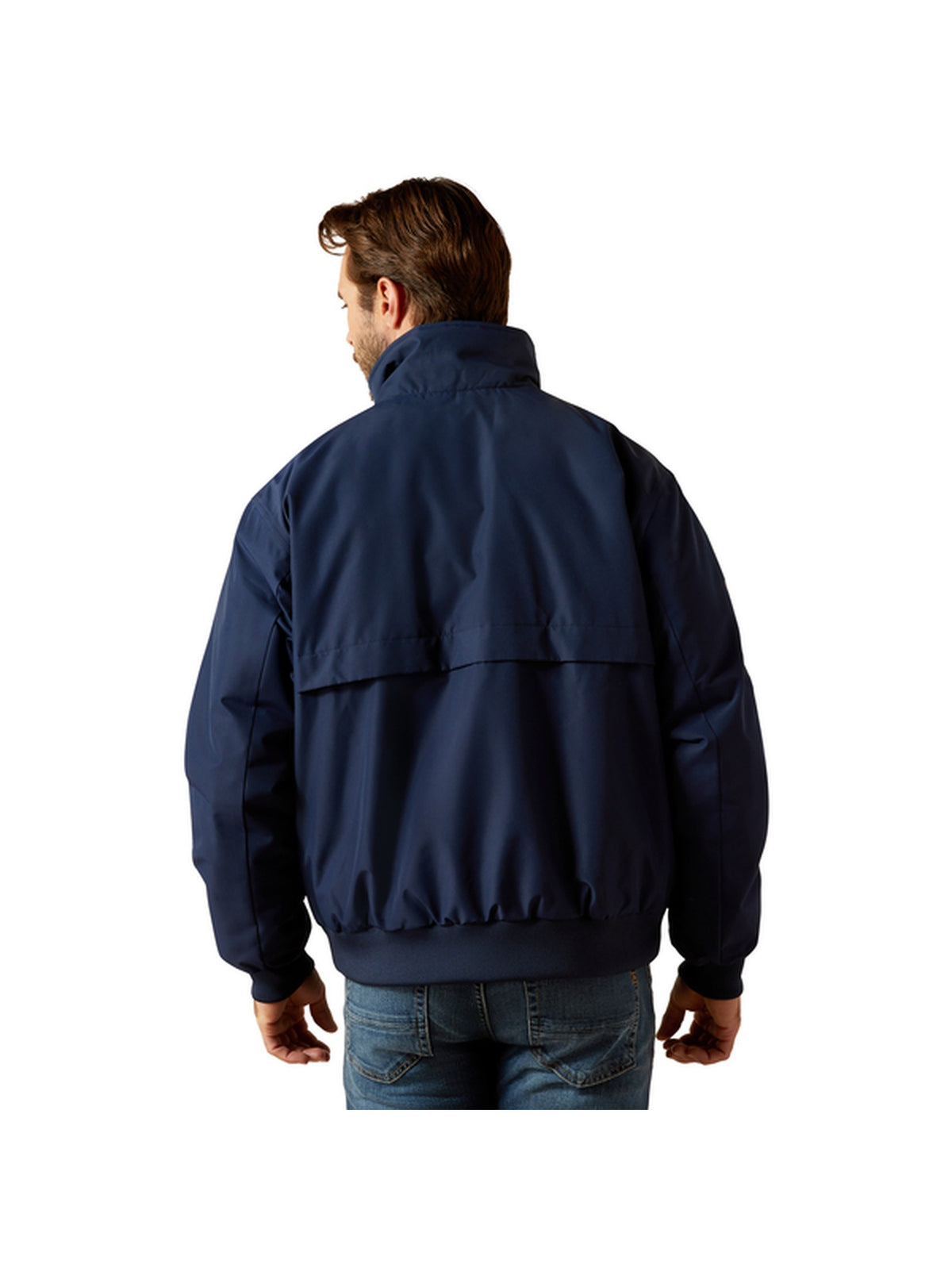 A man viewed from behind wearing a navy blue lightweight jacket and blue jeans, isolated on a white background.